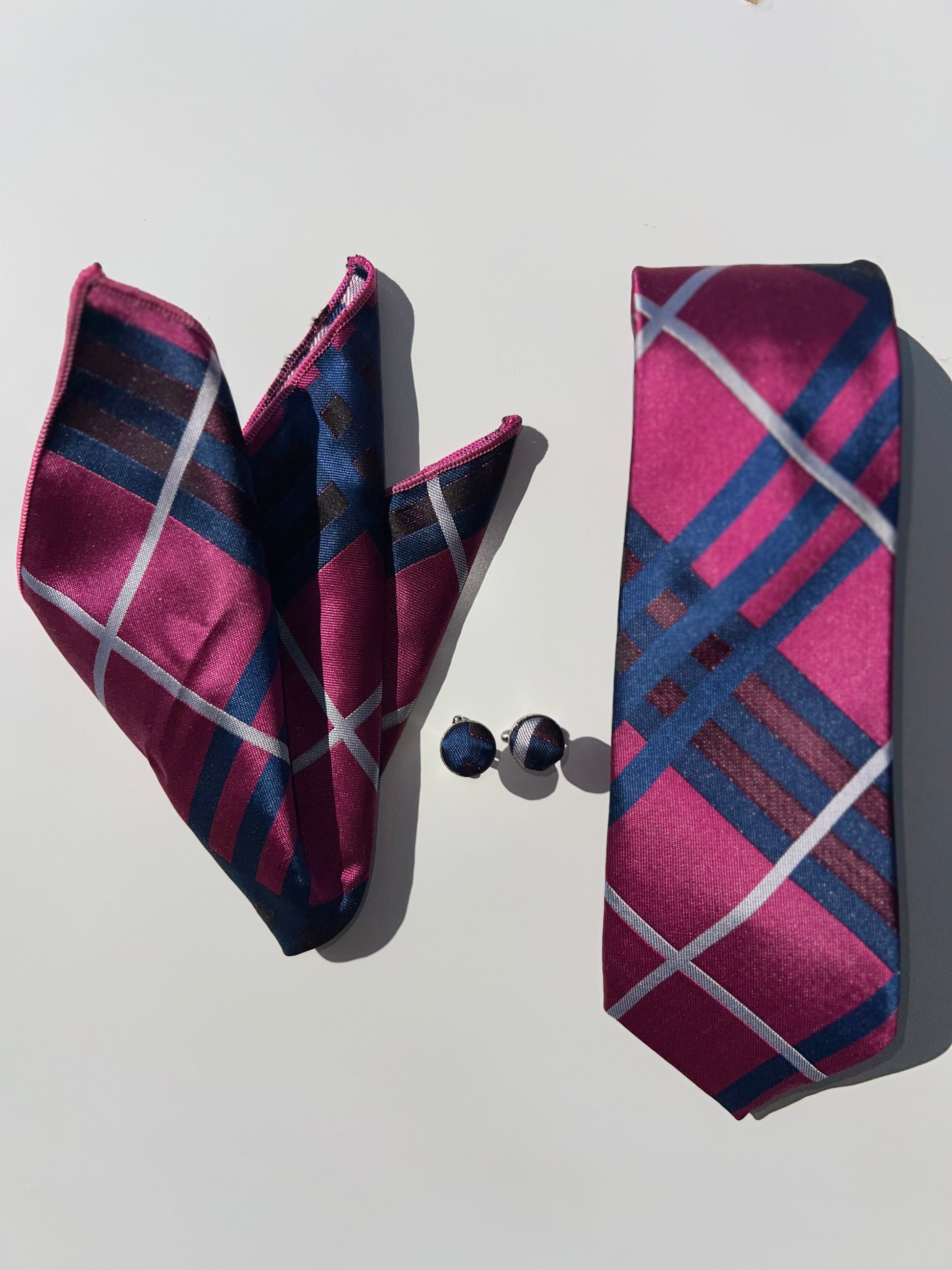 Regal Stripes Tie Set with pink and navy striped silk tie, pocket square, and cufflinks on a white surface.