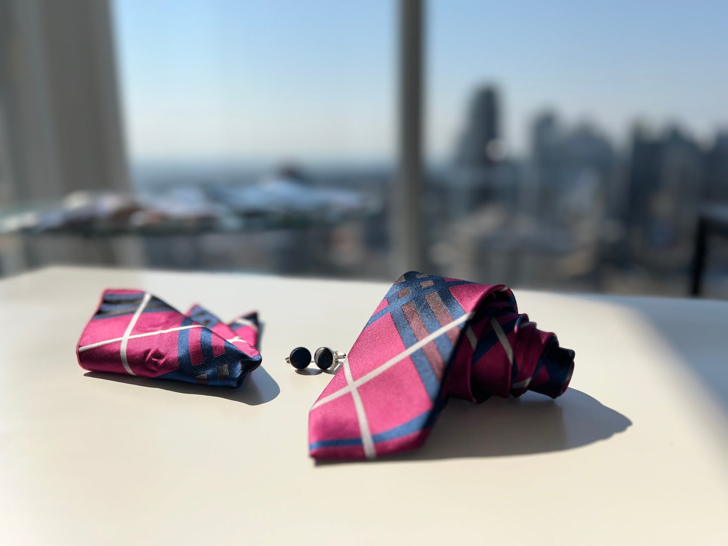 Close-up of the vibrant pink and navy blue striped tie with cufflinks.