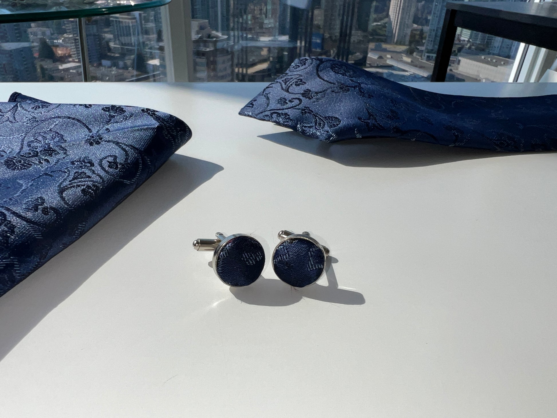 Elegant set of navy blue paisley cufflinks on a white surface, perfect for formal attire