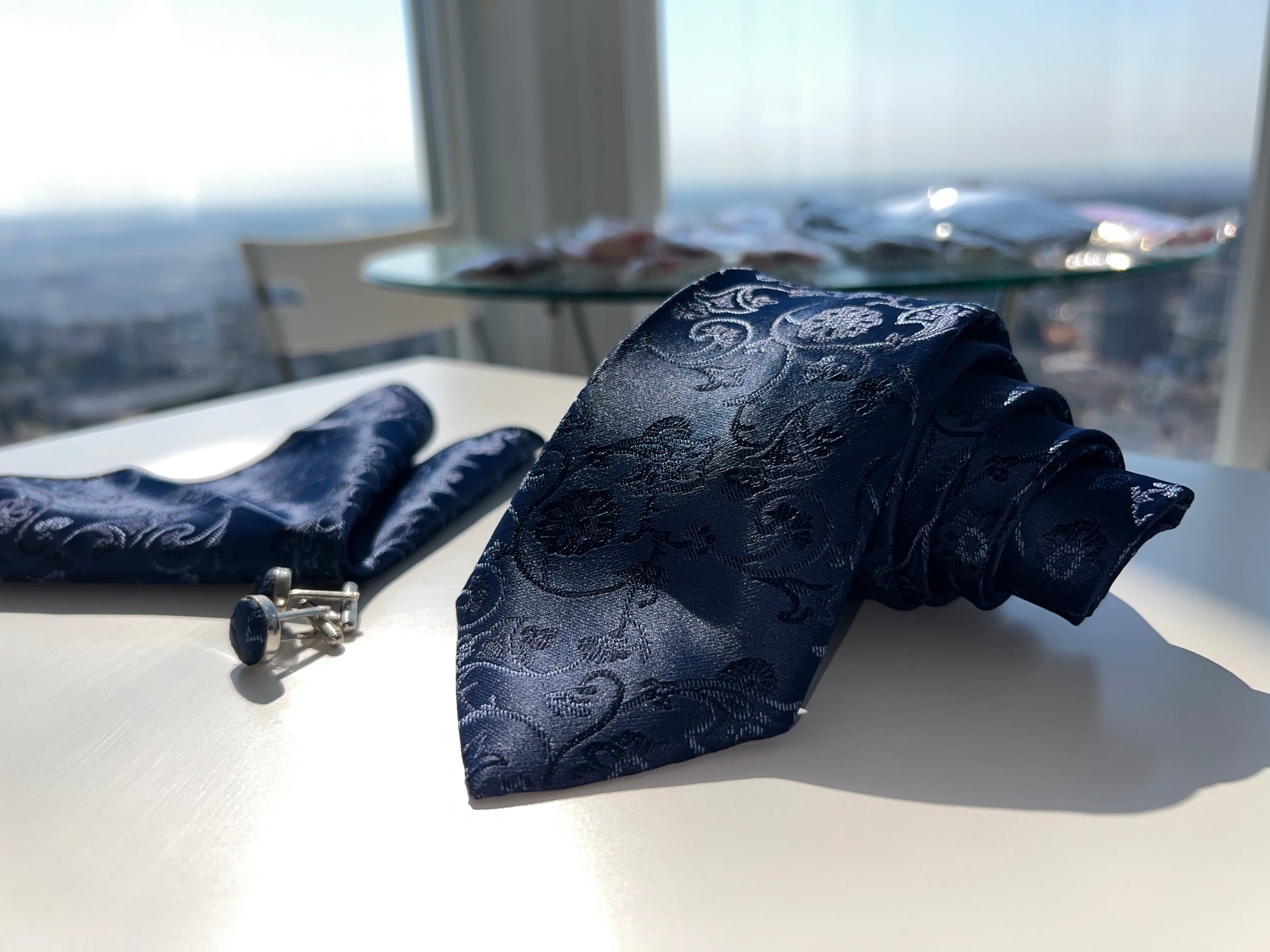 Elegant set of navy blue paisley cufflinks on a white surface, perfect for formal attire