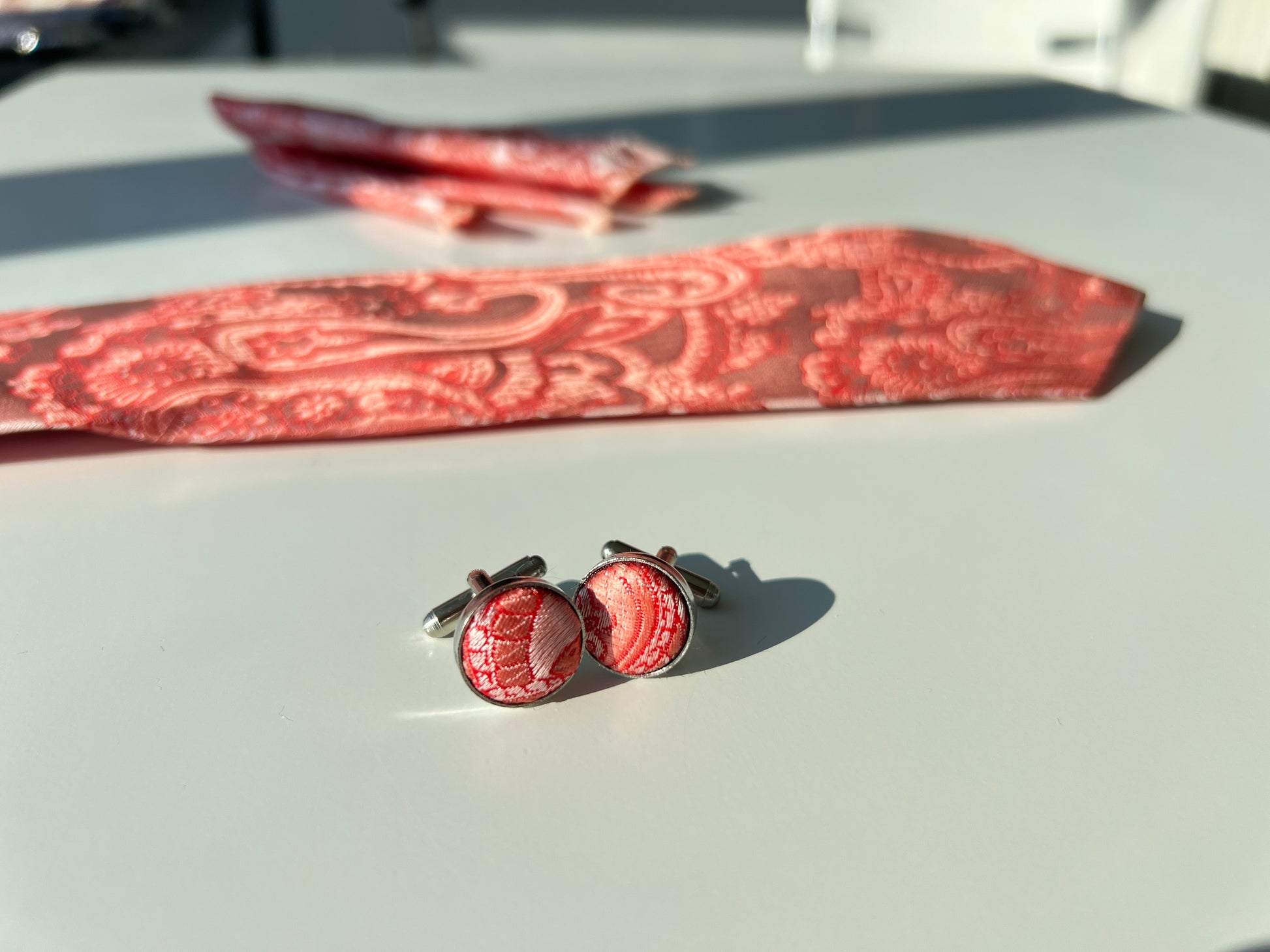 Detailed view of the regal red paisley pattern on silk cufflinks