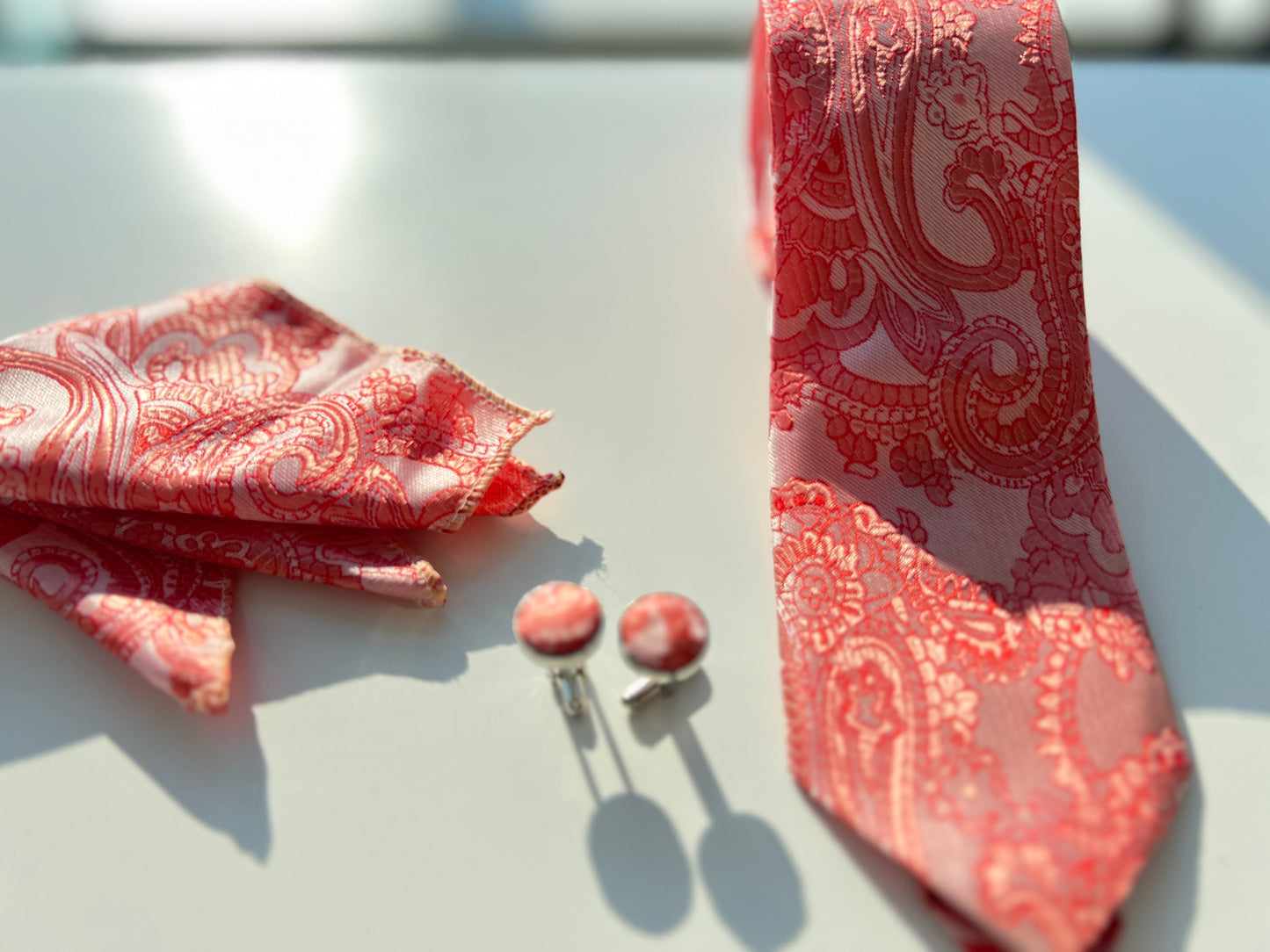 Detailed view of the red paisley pattern on silk tie and cufflinks