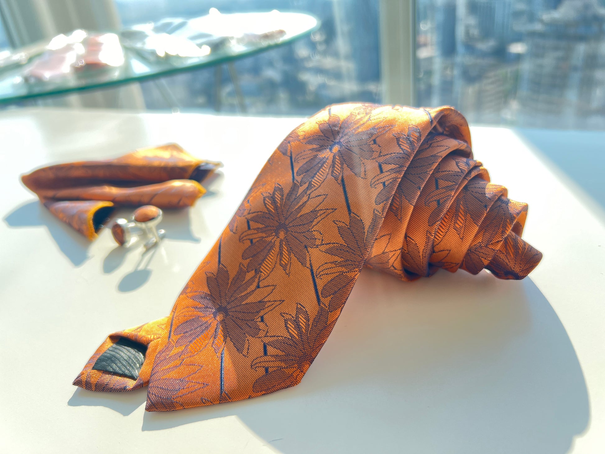 Elegant bronze floral pocket square and tie set displayed