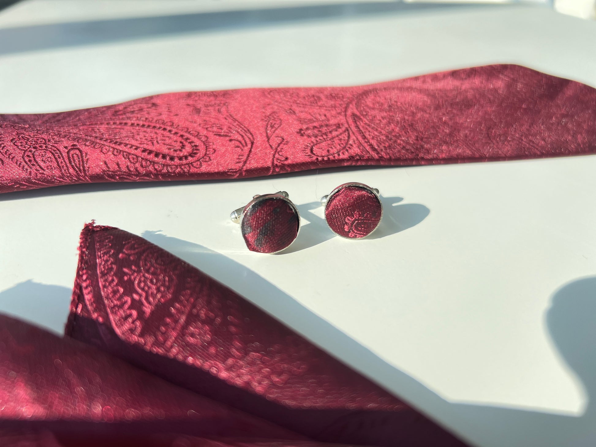 deep red paisley tie set with close-up cufflink focused shot